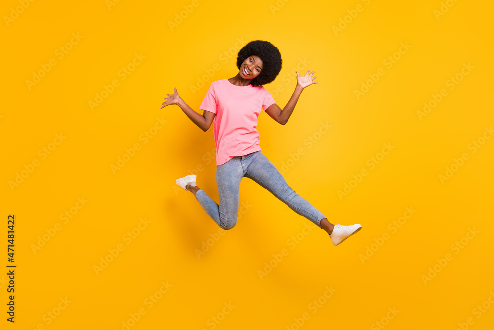 Full body photo of funky millennial lady jump wear pink t-shirt jeans isolated on yellow color background
