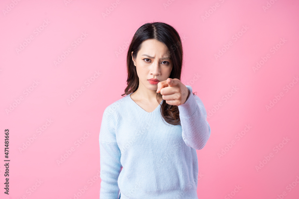 Fototapeta premium Portrait of a beautiful young Asian girl, isolated on pink background