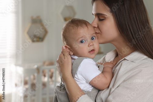Happy young mother with her baby in nursery. Space for text