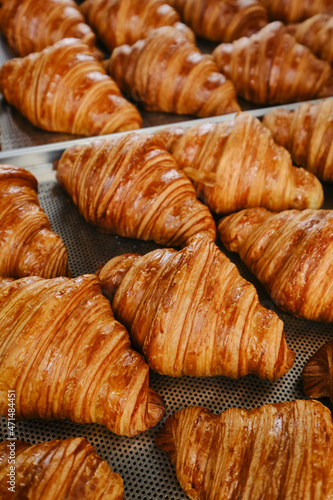 Freshly baked golden French croissants on baking sheet. Fresh classic pastries. Close up . High quality photo