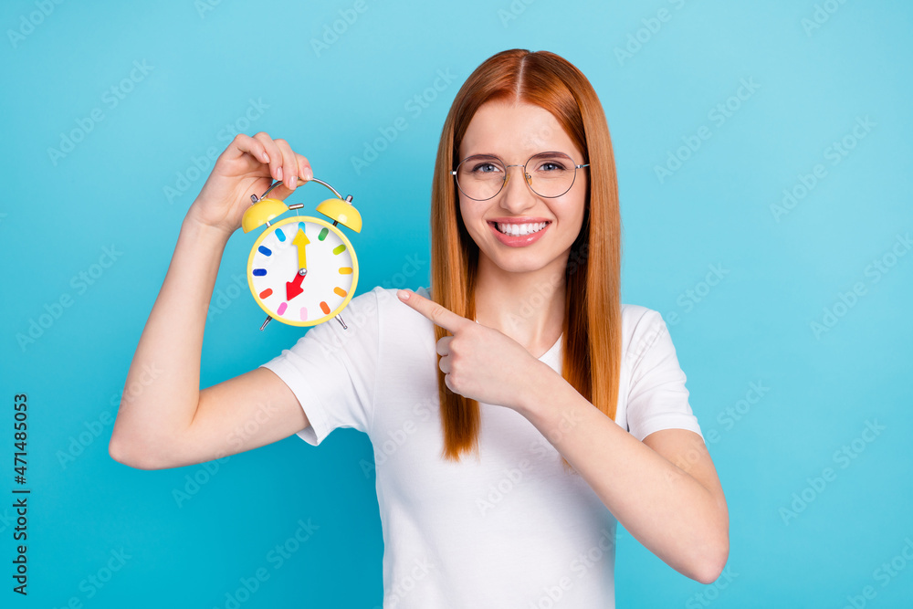 Photo of young girl happy positive smile point finger watch clock choice deadline select isolated over blue color background Photo of young girl happy positive smile point finger watch clock choice deadline select isolated over blue color background
