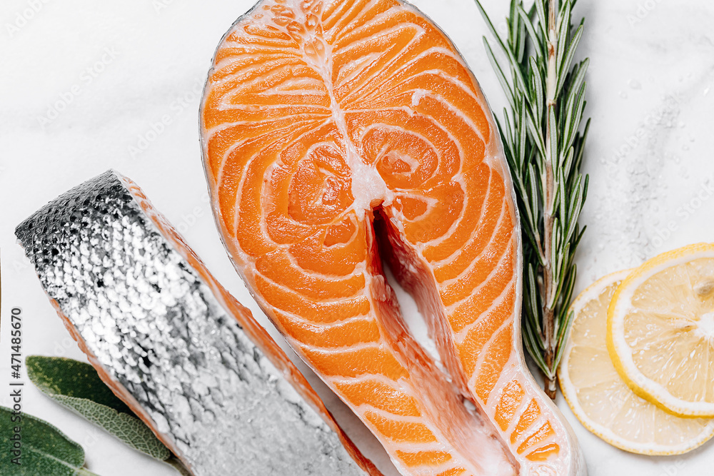 two raw salmon steaks on a white marble surface. the concept of a healthy dinner for two from salmon steaks. fresh salmon steaks.