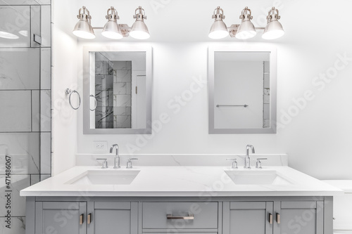 Papier peint An elegant, remodeled bathroom with a grey vanity and bronze hardware