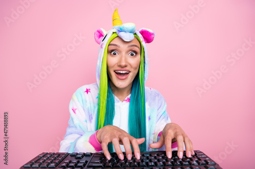 Portrait of attractive amazed cheery girl wearing kigurumi typing chatting isolated over pink pastel color background photo