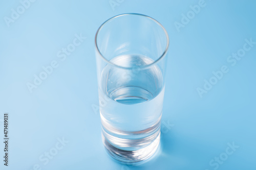 Glass of pure cold water on a blue background.