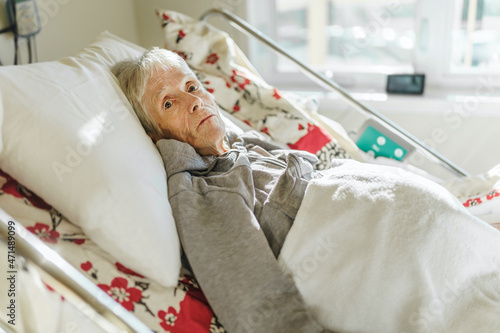 Bild auf Leinwand Sick, elderly senior woman in a hospital bed