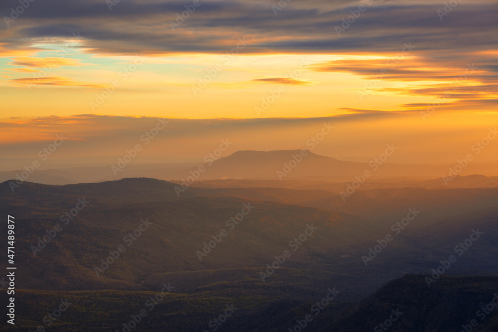 Glowing sunrise shines over mountain range.