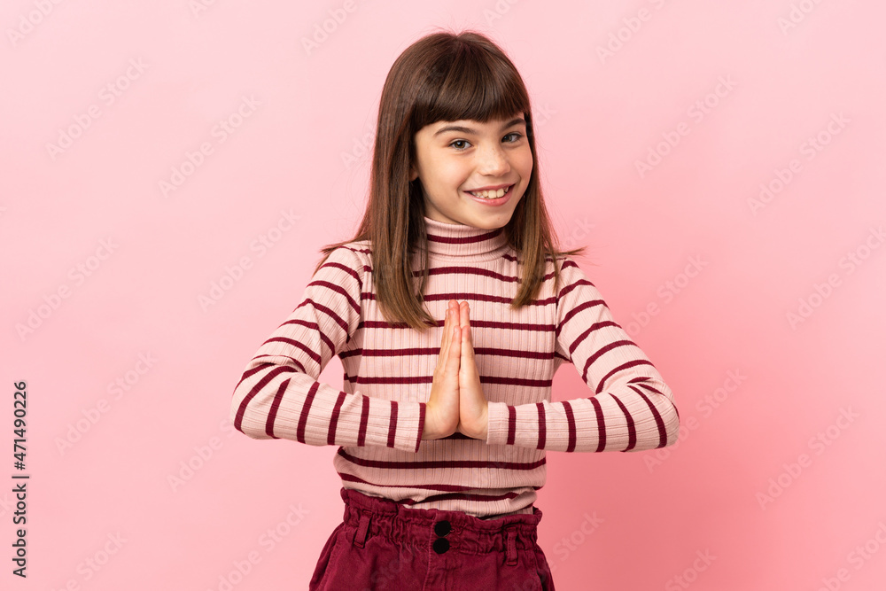 Little girl isolated on pink background keeps palm together. Person asks for something Little girl isolated on pink background keeps palm together. Person asks for something