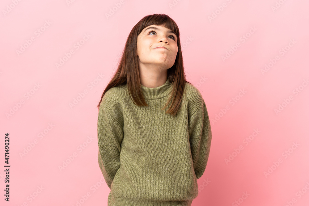Little girl isolated on pink background and looking up Little girl isolated on pink background and looking up