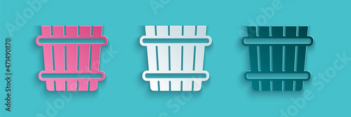 Paper cut Sauna bucket icon isolated on blue background. Paper art style. Vector