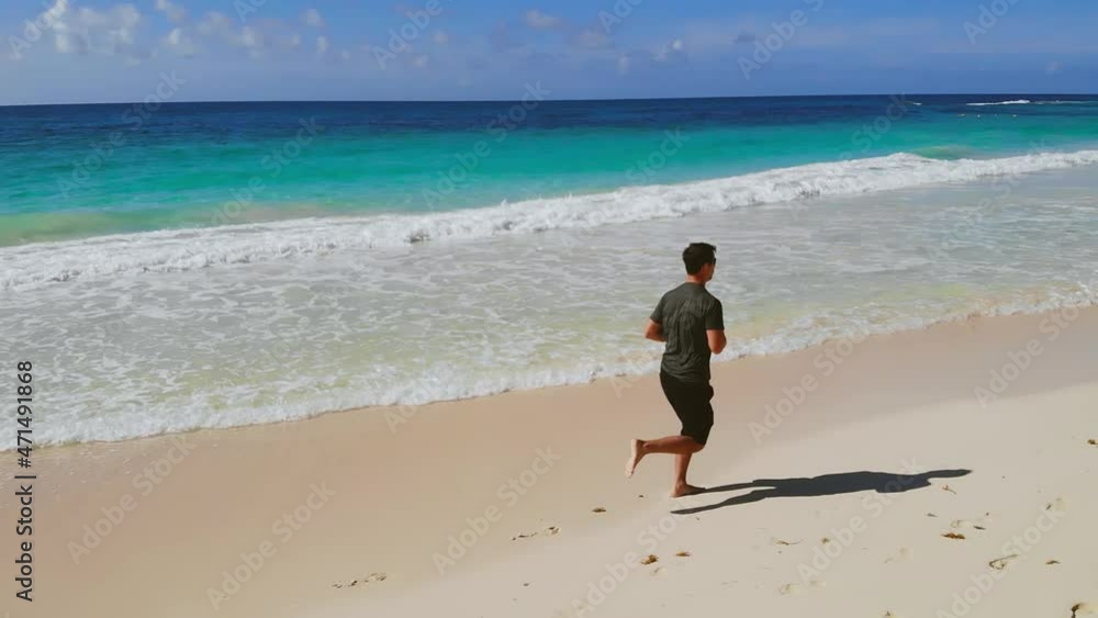 Athletic man jogger running at nature beach sea landscape. Male runner barefoot training at coast scenery practicing intensive cardio activity healthy lifestyle. Running man outdoors beach run. Athletic man jogger running at nature beach sea landscape. Male runner barefoot training at coast scenery practicing intensive cardio activity healthy lifestyle. Running man outdoors beach run.