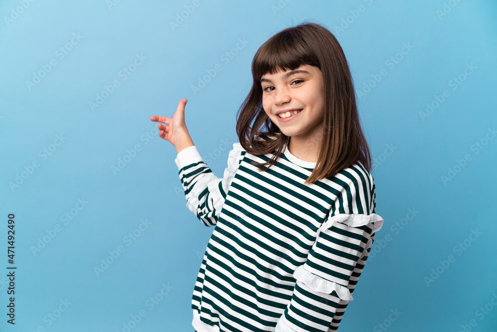 Little girl over isolated background pointing back Little girl over isolated background pointing back