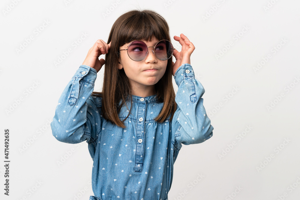 Little girl with sunglasses isolated on white background having doubts and thinking Little girl with sunglasses isolated on white background having doubts and thinking