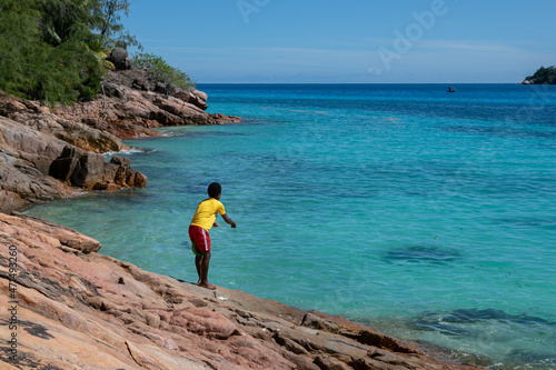 Fototapeta A young Seychelles fisherman is fishing on his home island