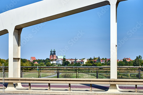 The steel structure of the bridge over the Warta River overlooking the Gothic cathedral
