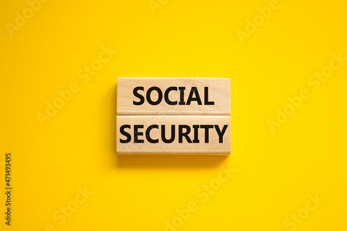 Time to social security symbol. Concept words Social security on wooden blocks on a beautiful yellow background. Business and social security concept. Copy space.