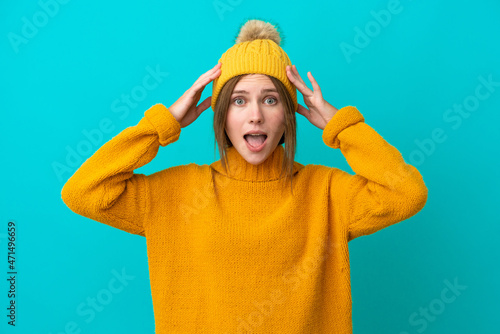 Young English woman wearing winter jacket isolated on blue background with surprise expression © luismolinero