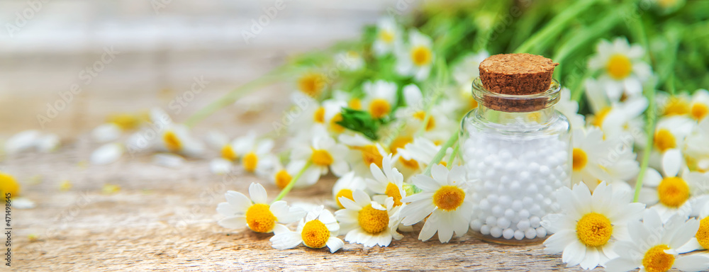 Homeopathy pills chamomile in a small bottle. Selective focus. Homeopathy pills chamomile in a small bottle. Selective focus.
