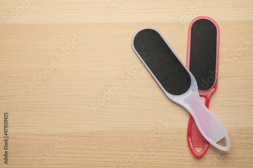 Colorful foot files on wooden table  flat lay with space for text. Pedicure tools