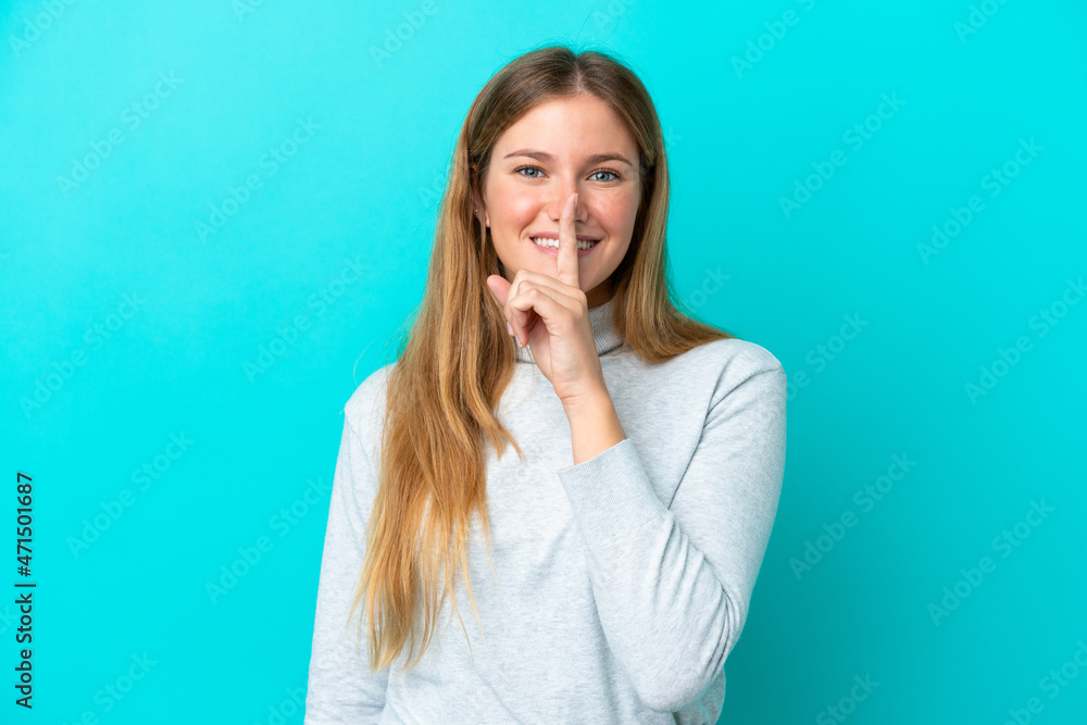 Young blonde woman isolated on blue background showing a sign of silence gesture putting finger in mouth Young blonde woman isolated on blue background showing a sign of silence gesture putting finger in mouth