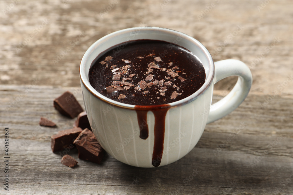 Fototapeta premium Yummy hot chocolate in cup on wooden table