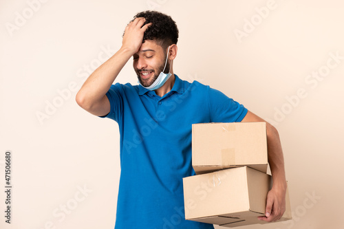 Young delivery Moroccan man isolated on beige background has realized something and intending the solution