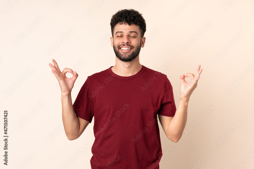 Young Moroccan man isolated on beige background in zen pose Young Moroccan man isolated on beige background in zen pose