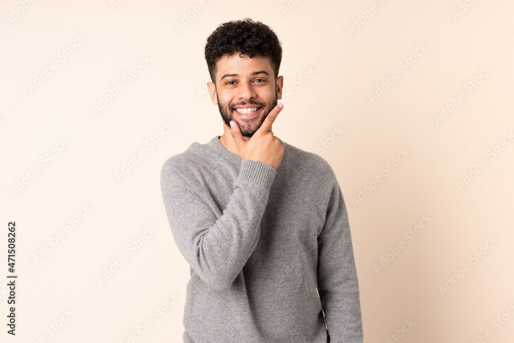 Young Moroccan man isolated on beige background happy and smiling Young Moroccan man isolated on beige background happy and smiling