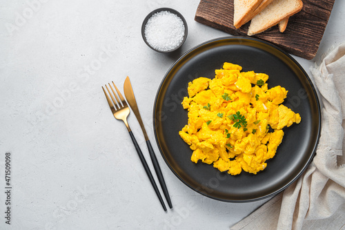 Tableau sur toile A portion of scrambled eggs with parsley on a gray background