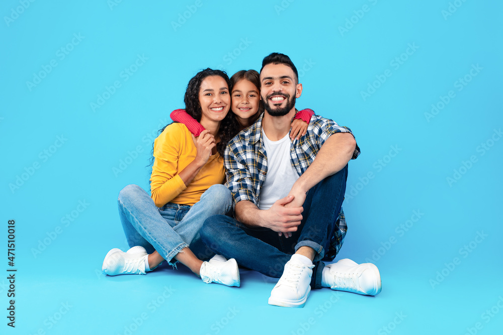 Loving Arab Family Hugging Sitting In Studio Over Blue Background Loving Arab Family Hugging Sitting In Studio Over Blue Background