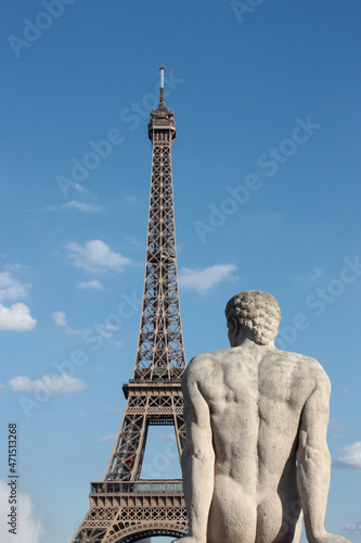 stone statue of man with eiffel tower