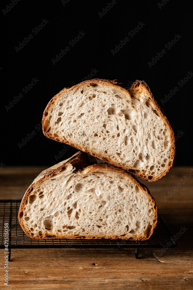 Baked sourdough bread on grill pan placed on wooden surface Baked sourdough bread on grill pan placed on wooden surface