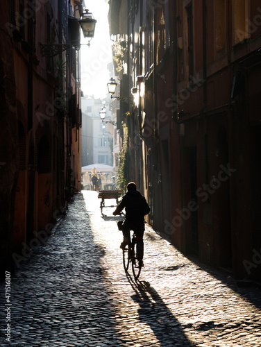 person riding a bike in an alley in Rome, Italy © HumbleBee