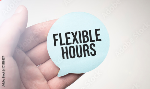 Businessman holding speech buble paper with a message FLEXIBLE HOURS