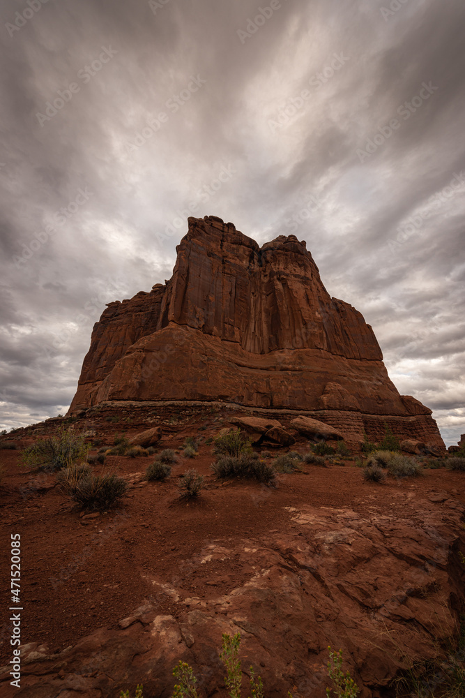 Courthouse rock formation in Arches National Park under moody dramatic sky weather, Utah