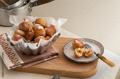 Deep fried beignets doughnut placed on wooden tray photo