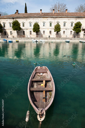 Obraz na płótnie A boat moored in the canal in Peschiera-garda lake-Italy w salonie