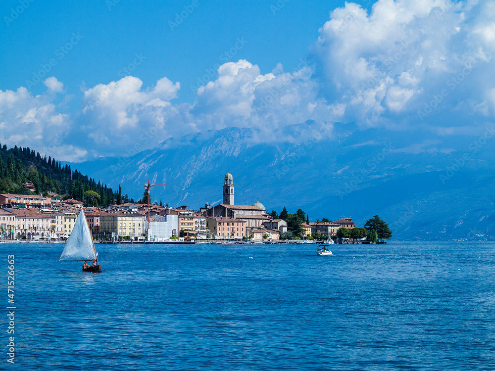 Some sailboats sail in front of Salò-Garda lake-Italy