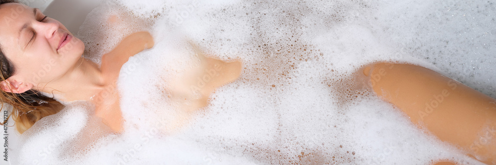 Young nude woman lying in bubble bath Young nude woman lying in bubble bath