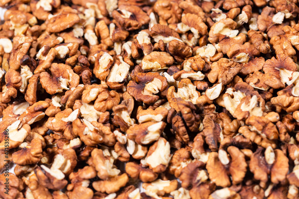 Pieces of peeled walnuts forming a solid background texture. Pieces of peeled walnuts forming a solid background texture.