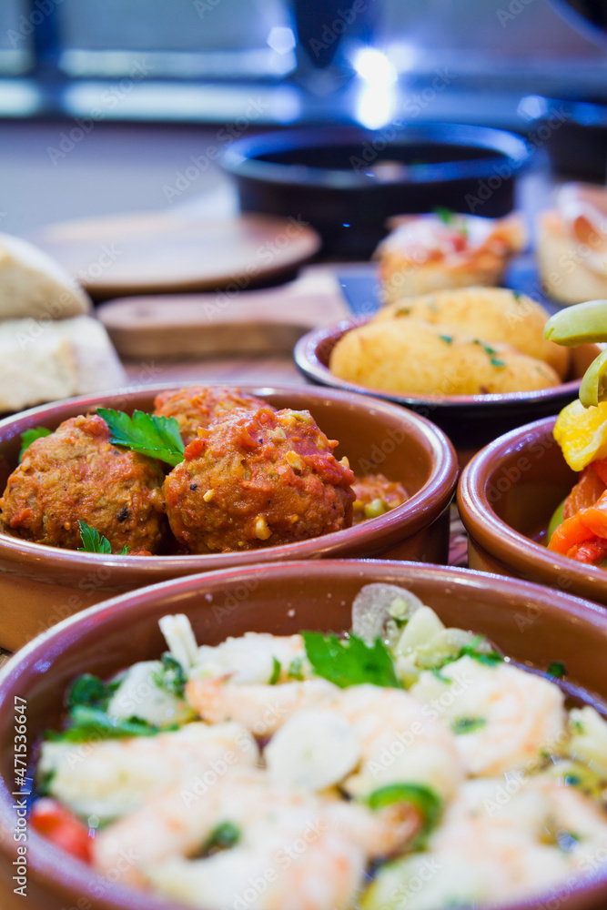 Tapas buffet with traditional Spanish cuisine dishes - Gambas, fish Crocuetes, Octopus, Chorizo Sausage and Serrano Ham.
