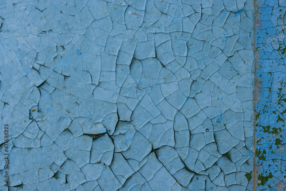 Blue peeling paint on the wall. Old concrete wall with cracked flaking paint. Weathered rough painted surface with patterns of cracks and peeling. High resolution texture for background and design. Blue peeling paint on the wall. Old concrete wall with cracked flaking paint. Weathered rough painted surface with patterns of cracks and peeling. High resolution texture for background and design.