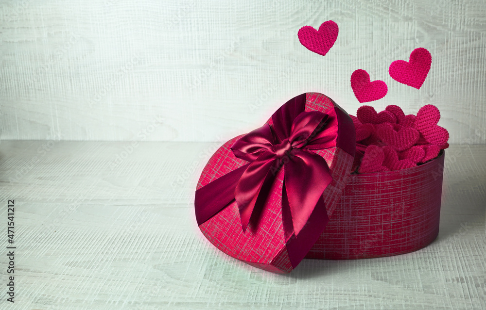 Single red gift box with fireworks from hearts on gray background. Single red gift box with fireworks from hearts on gray background.