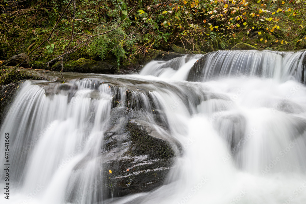 Long exposure of a waterfall flowing through the woods at Watersmeet in Exmoor National Park Long exposure of a waterfall flowing through the woods at Watersmeet in Exmoor National Park