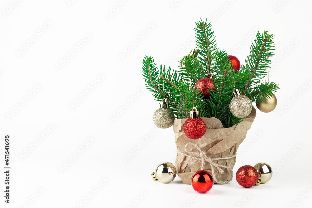 Small Christmas tree in a pot wrapped in paper with Christmas tree balls on white isolated background. little fir tree on white with copy space. Small Christmas tree in a pot wrapped in paper with Christmas tree balls on white isolated background. little fir tree on white with copy space.