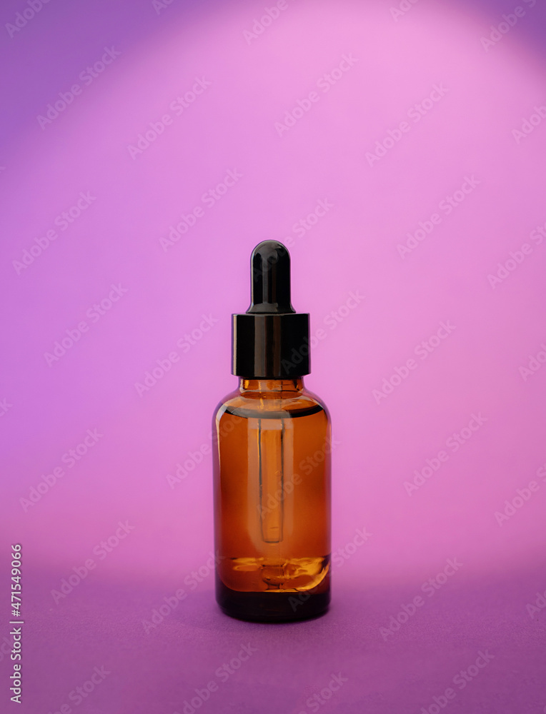 Cosmetic Bottle serum dark glass, oil cosmetic on velvet violet background, copy space. minimalism brand packaging mock up. Skin care. Almond Extract Cosmetic. Color trends 2022 Cosmetic Bottle serum dark glass, oil cosmetic on velvet violet background, copy space. minimalism brand packaging mock up. Skin care. Almond Extract Cosmetic. Color trends 2022