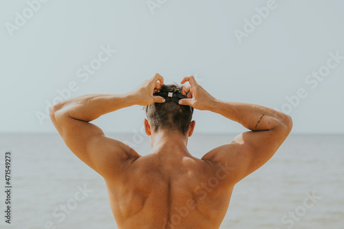 Hombre joven adolescente natacion. Deporte aire libre playa. Natacion naturaleza. Joven poniendose gafas de natacion.  photo