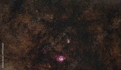 Night sky with many stars, milky way galaxy with purple Triffid and Lagoon nebulas visible photo