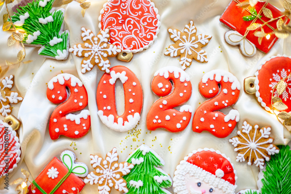 Banner for Christmas and New Year gingerbread cookies numbers 2022, snowflakes, Santa hat, Christmas trees, garlands on white silk fabric background