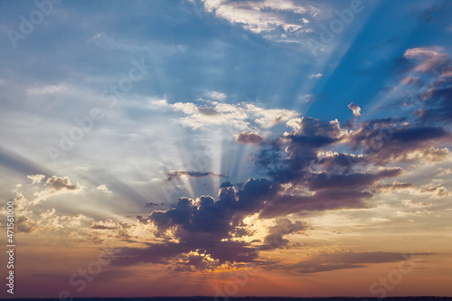 Obraz na płótnie Dramatic colorful sky background with rays of rising sun through clouds w salonie